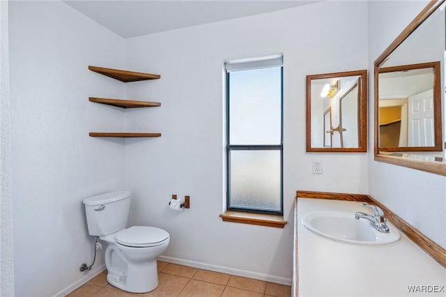 bathroom featuring toilet, vanity, baseboards, and tile patterned floors