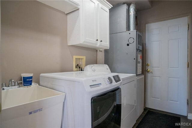 laundry room featuring cabinet space, a sink, and separate washer and dryer