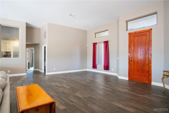 living area featuring recessed lighting, a towering ceiling, visible vents, baseboards, and dark wood finished floors