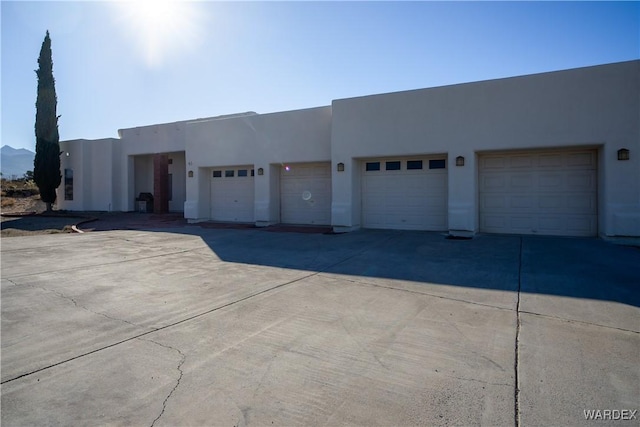 view of front facade featuring a garage, a mountain view, and stucco siding