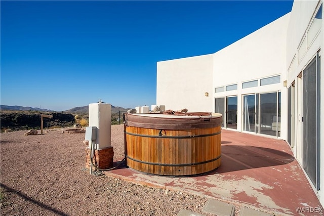 exterior space with a mountain view and a hot tub