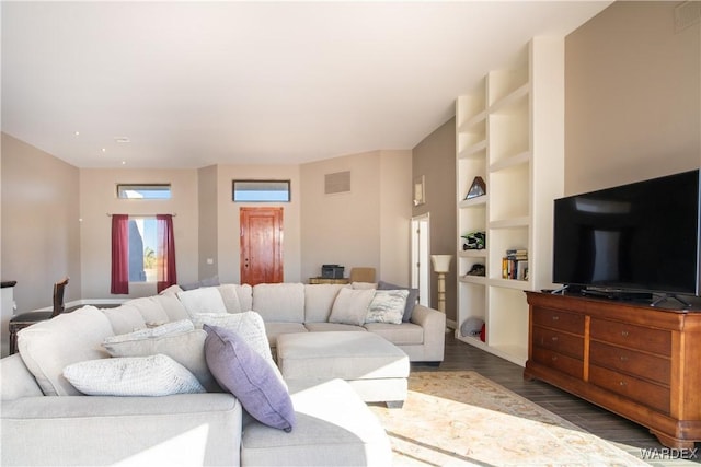 living area with dark wood-type flooring, visible vents, and built in features