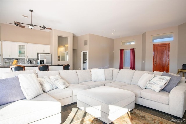 living area with wood tiled floor, visible vents, and ceiling fan