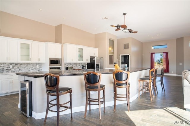 kitchen featuring white cabinetry, a kitchen island with sink, and glass insert cabinets