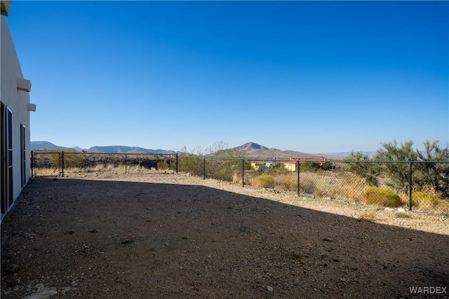 view of yard featuring a mountain view and fence