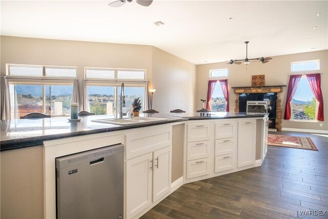 kitchen featuring white cabinetry, open floor plan, dishwasher, and a stone fireplace