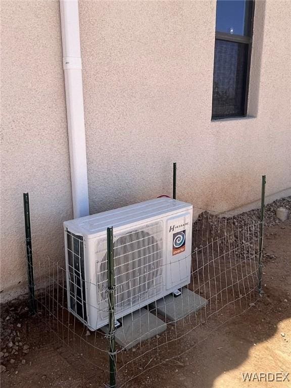 exterior details featuring ac unit, fence, and stucco siding