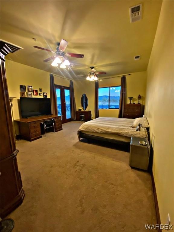 carpeted bedroom featuring access to exterior, visible vents, and a ceiling fan