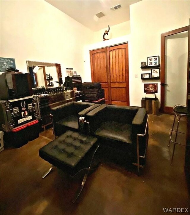 living area with vaulted ceiling, visible vents, and dark carpet