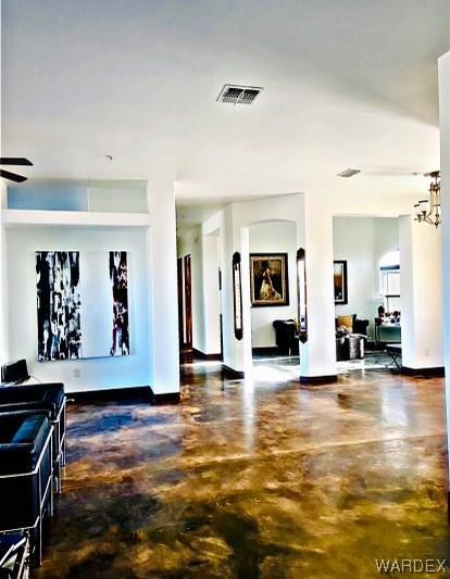 interior space with baseboards, concrete floors, and visible vents