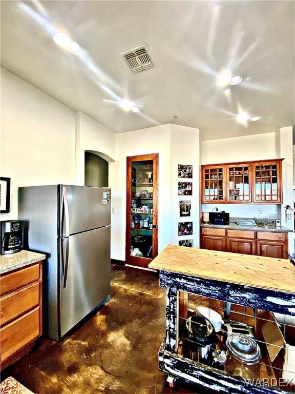 living area with ceiling fan, concrete floors, and visible vents