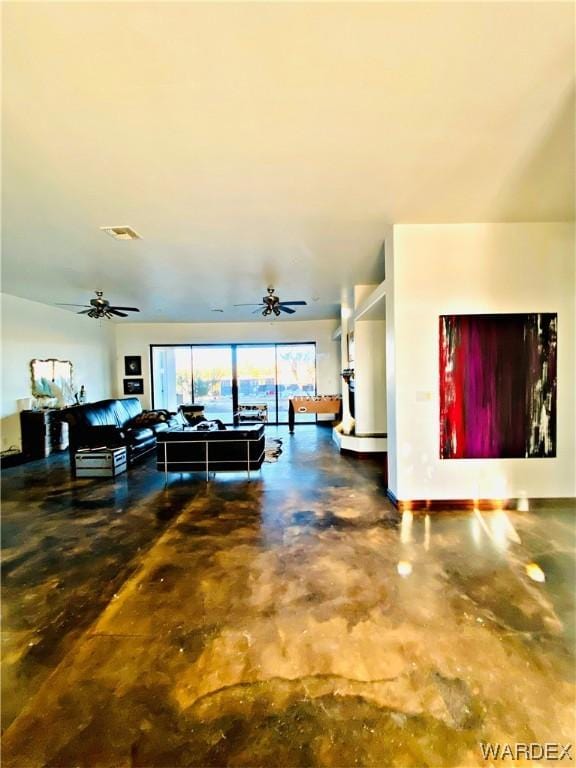 living area featuring finished concrete floors, visible vents, and a ceiling fan