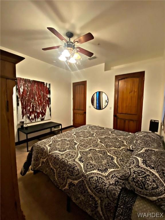 carpeted bedroom featuring visible vents and a ceiling fan