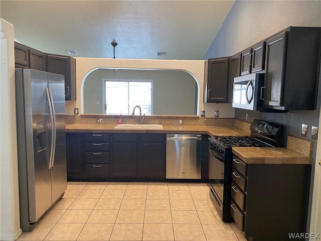 kitchen featuring appliances with stainless steel finishes, plenty of natural light, a sink, and light tile patterned floors