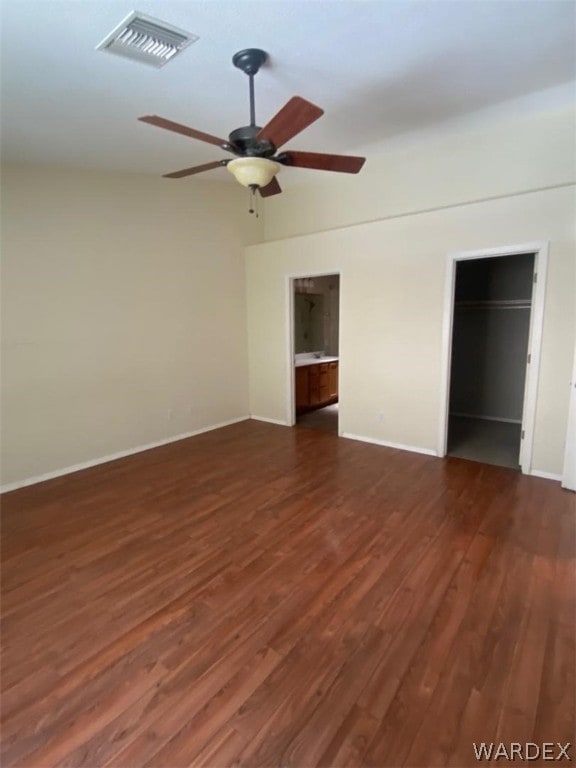 unfurnished bedroom with ceiling fan, dark wood-style flooring, visible vents, baseboards, and vaulted ceiling