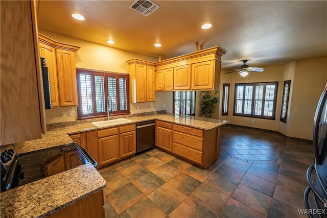 kitchen with visible vents, a peninsula, a healthy amount of sunlight, black appliances, and a sink