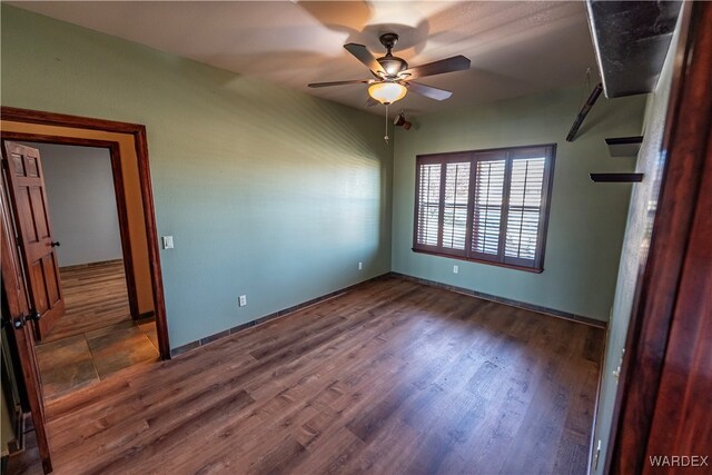 unfurnished bedroom featuring ceiling fan and dark wood finished floors