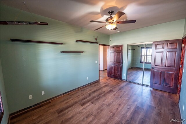 unfurnished bedroom with ceiling fan, a closet, baseboards, and wood finished floors