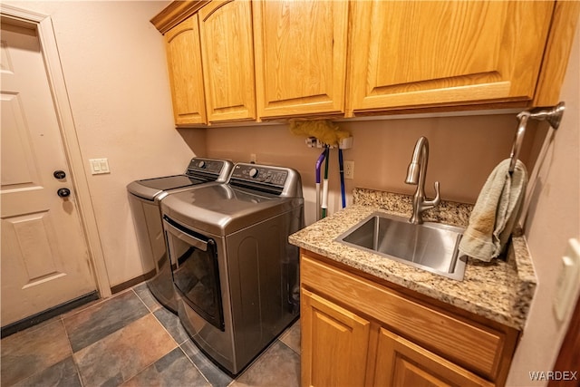 laundry area featuring cabinet space, washer and dryer, and a sink