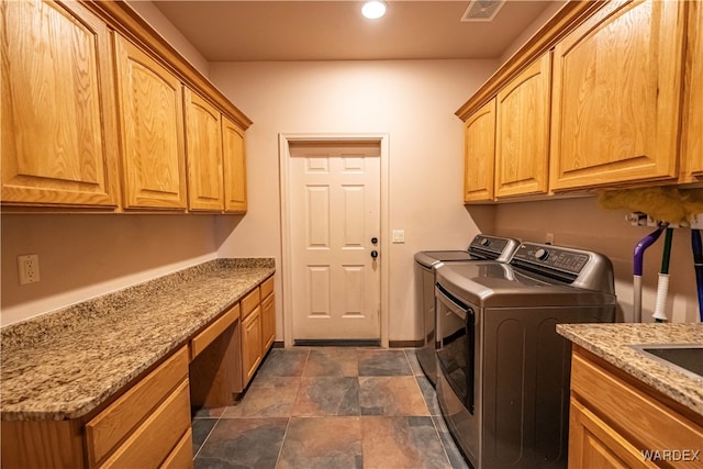 washroom featuring recessed lighting, cabinet space, visible vents, stone finish flooring, and separate washer and dryer