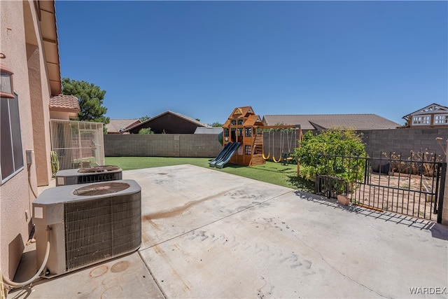 view of patio / terrace with central AC, a playground, and a fenced backyard