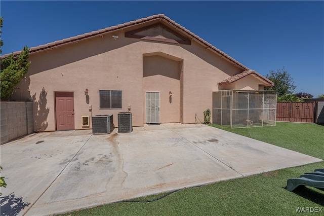 rear view of house featuring central air condition unit, a yard, a patio, and stucco siding