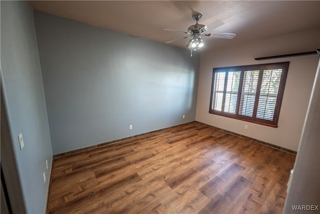 empty room with a ceiling fan and wood finished floors