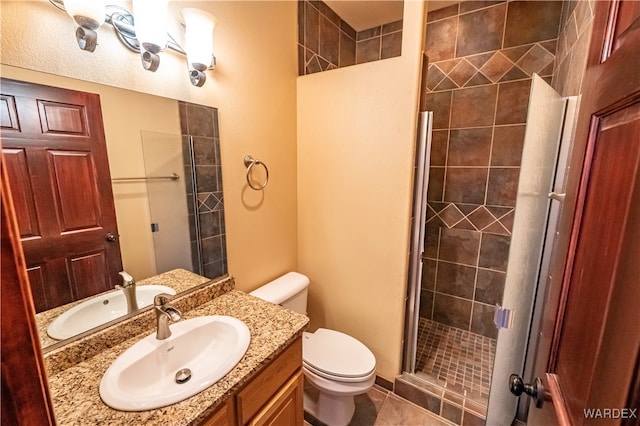 full bathroom featuring tile patterned flooring, toilet, vanity, and a shower stall