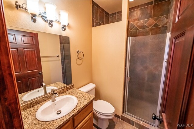 full bathroom featuring toilet, a stall shower, vanity, and tile patterned floors