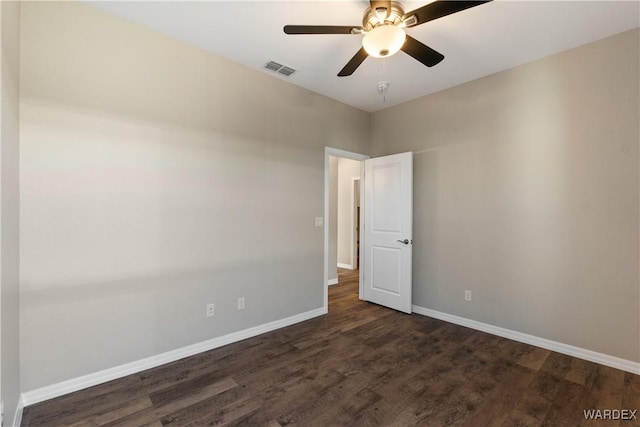 empty room with a ceiling fan, dark wood finished floors, visible vents, and baseboards