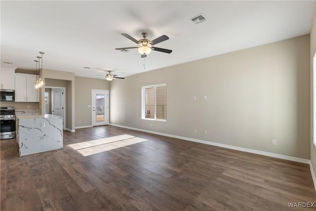 kitchen featuring stainless steel appliances, visible vents, white cabinets, open floor plan, and decorative light fixtures