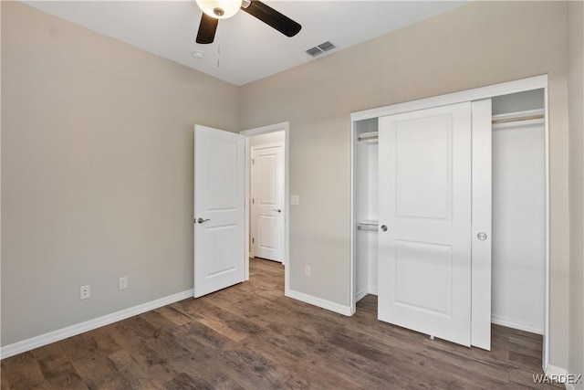 unfurnished bedroom with dark wood-style flooring, a closet, visible vents, a ceiling fan, and baseboards