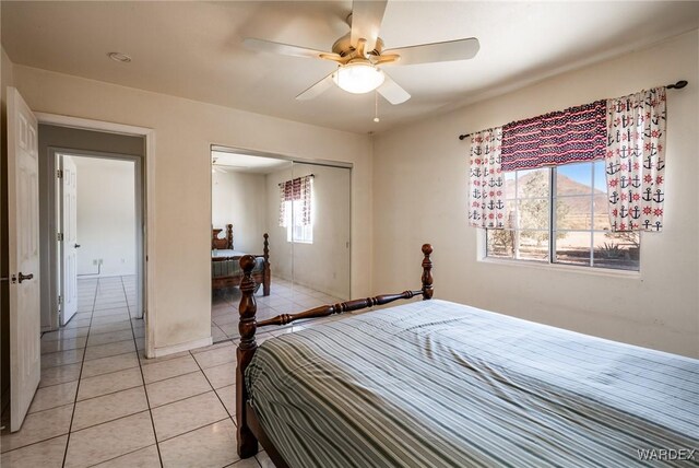 bedroom featuring light tile patterned floors, ceiling fan, and a closet