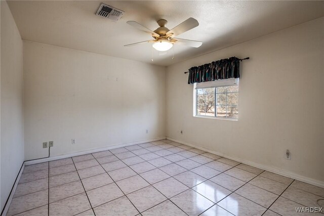 spare room featuring visible vents, ceiling fan, and baseboards