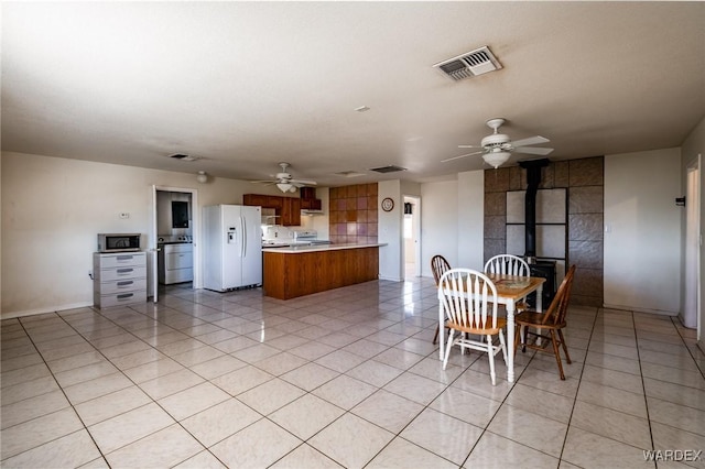 dining space featuring ceiling fan, light tile patterned floors, visible vents, and baseboards