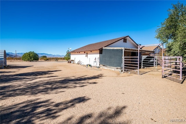 view of outbuilding featuring a rural view, an outdoor structure, an exterior structure, and a mountain view