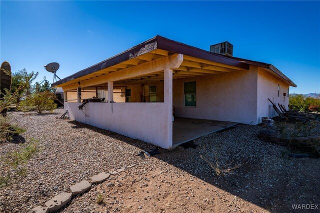 view of property exterior featuring central AC unit, a patio, and stucco siding