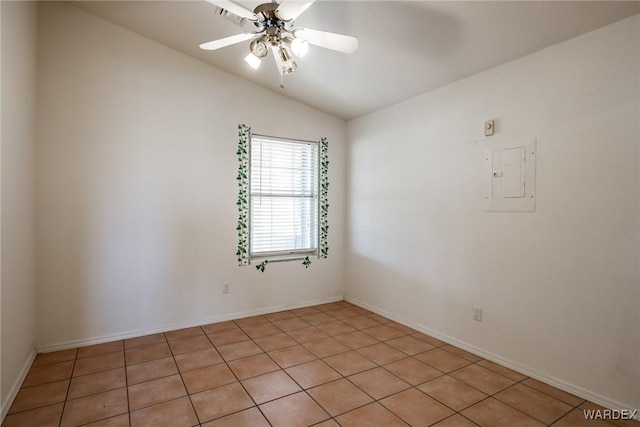 spare room featuring ceiling fan, vaulted ceiling, electric panel, and baseboards