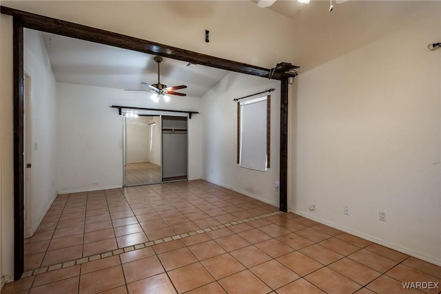 unfurnished bedroom with light tile patterned floors, baseboards, a ceiling fan, lofted ceiling with beams, and a closet