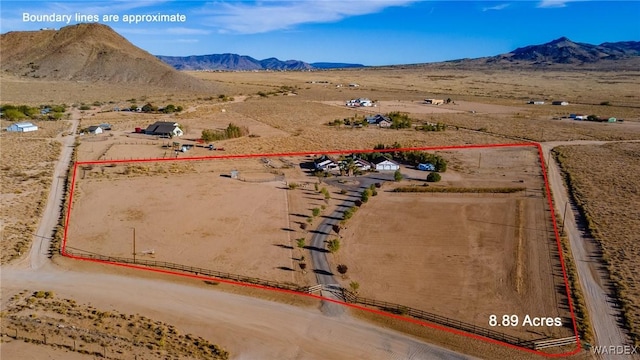 drone / aerial view featuring view of desert, a mountain view, and a rural view