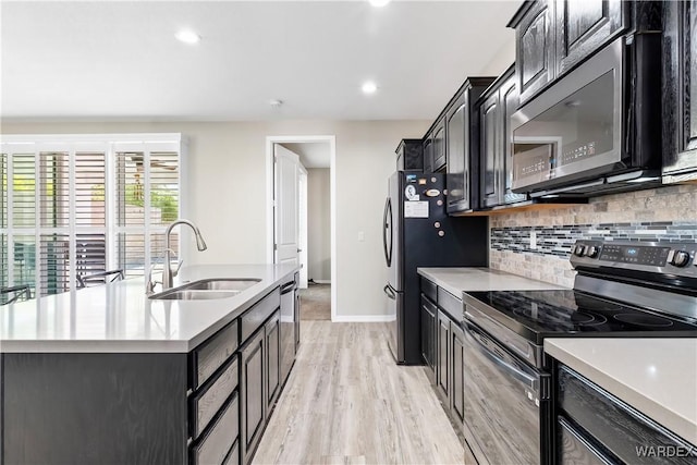 2542 E Alterna Dr, Fort Mohave, AZ 86426 - kitchen with a sink, backsplash, light countertops, an island with sink, and appliances with stainless steel finishes