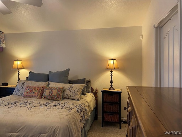 bedroom featuring carpet flooring, ceiling fan, and a textured ceiling