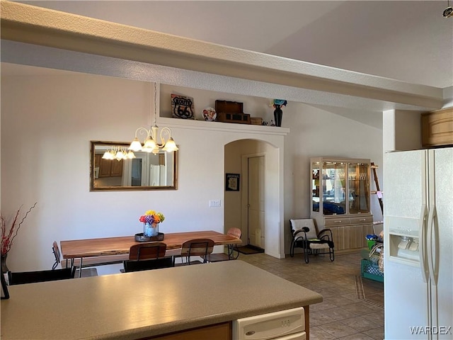 dining room featuring arched walkways, light tile patterned flooring, and a notable chandelier