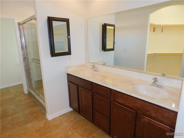 full bathroom with a sink, baseboards, and a shower stall