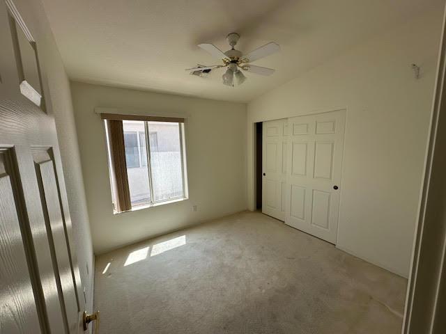 2195 Hijolly Dr, Bullhead City, AZ 86442 - unfurnished bedroom with light colored carpet, a closet, and a ceiling fan