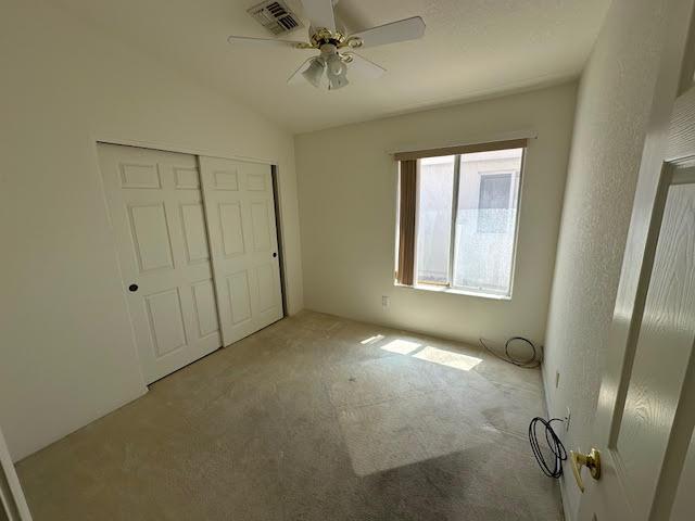 2195 Hijolly Dr, Bullhead City, AZ 86442 - unfurnished bedroom with carpet flooring, a closet, lofted ceiling, and ceiling fan