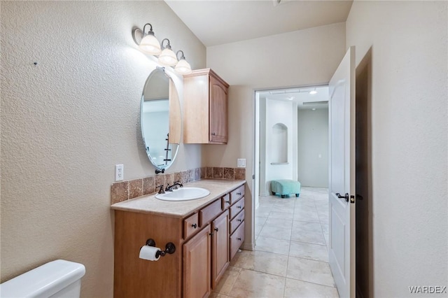 bathroom with toilet, tile patterned floors, and vanity