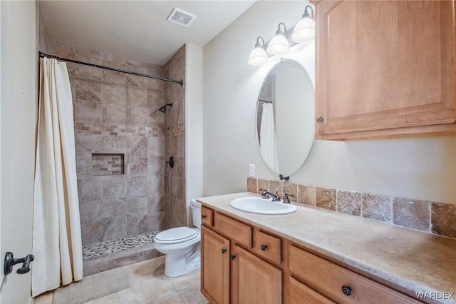 bathroom featuring toilet, a stall shower, visible vents, and vanity