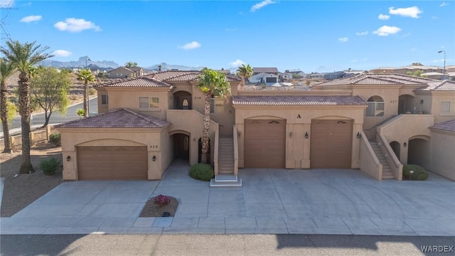 mediterranean / spanish house with a tile roof, driveway, stairway, a residential view, and stucco siding