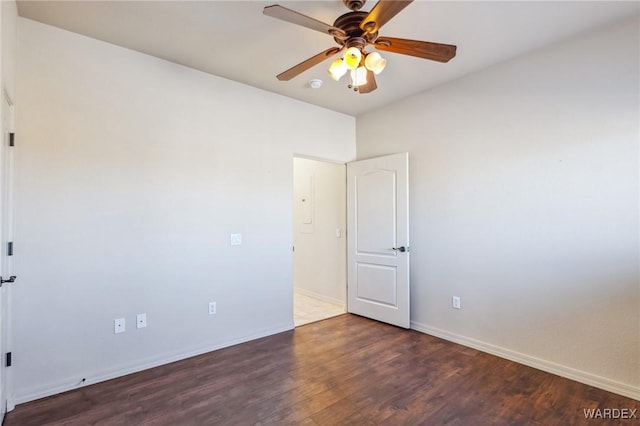 unfurnished room with dark wood-style floors, ceiling fan, and baseboards